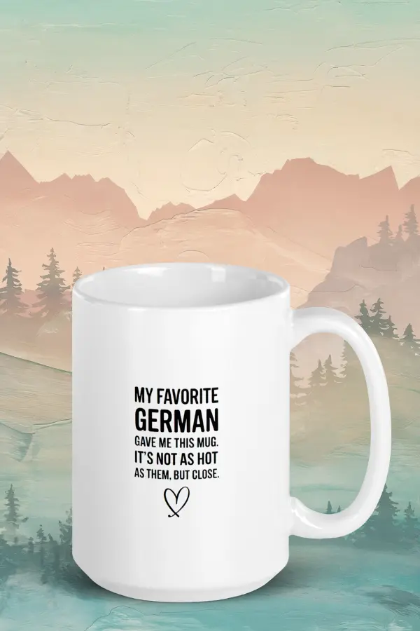 My favorite German mug Funny German mug with black text: "MY FAVORITE GERMAN GAVE ME THIS MUG. IT’S NOT AS HOT AS THEM. BUT CLOSE." Background shows a serene landscape with mountains and trees.