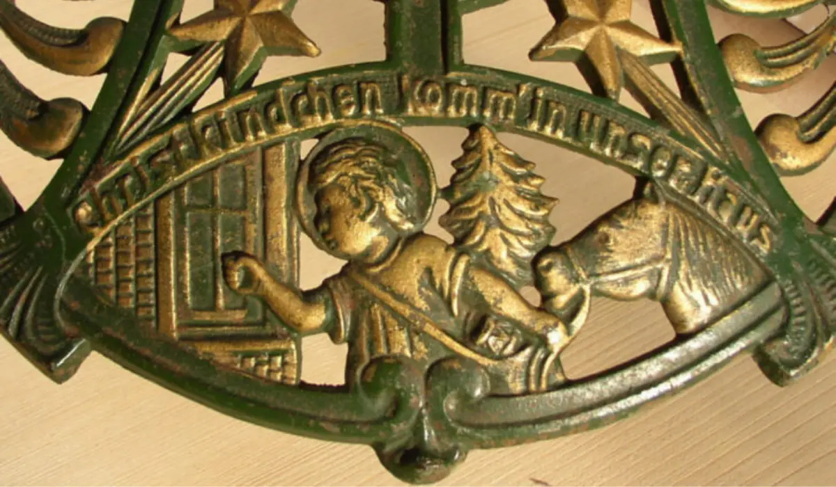 Bronze-colored vintage plaque depicting a child with a tree and a house, surrounded by stars, with German text.