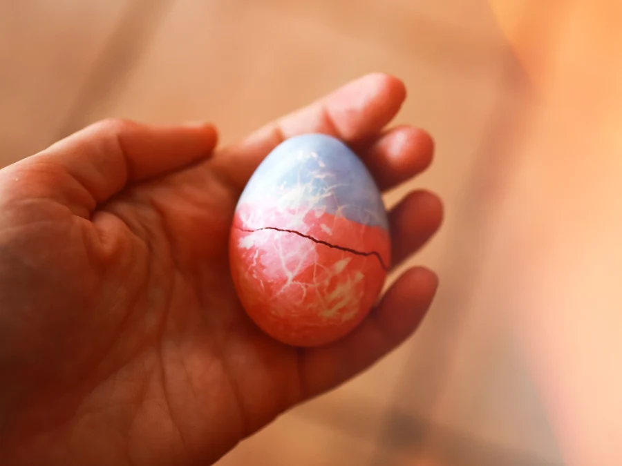 Hand holding a cracked dyed Easter egg after an Easter egg tapping game, part of German Easter traditions