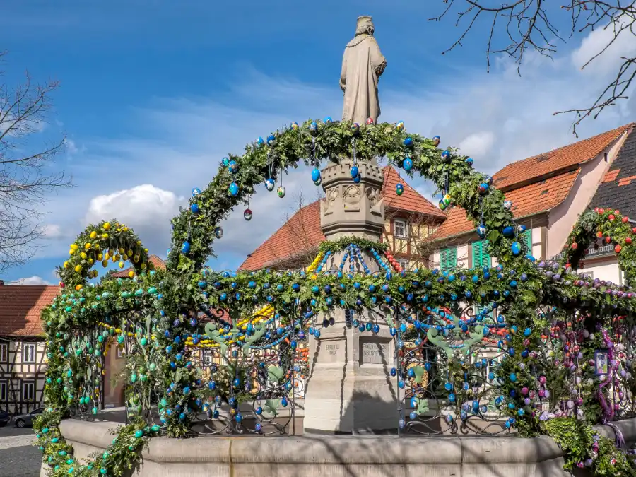 Decorated Osterbrunnen Easter fountain in a German village square, a traditional display for German Easter traditions