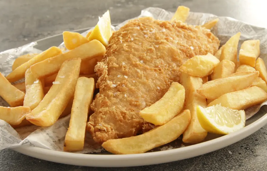 Crispy battered fish and chunky chips with lemon wedges, a Good Friday fish dinner in the German Easter tradition