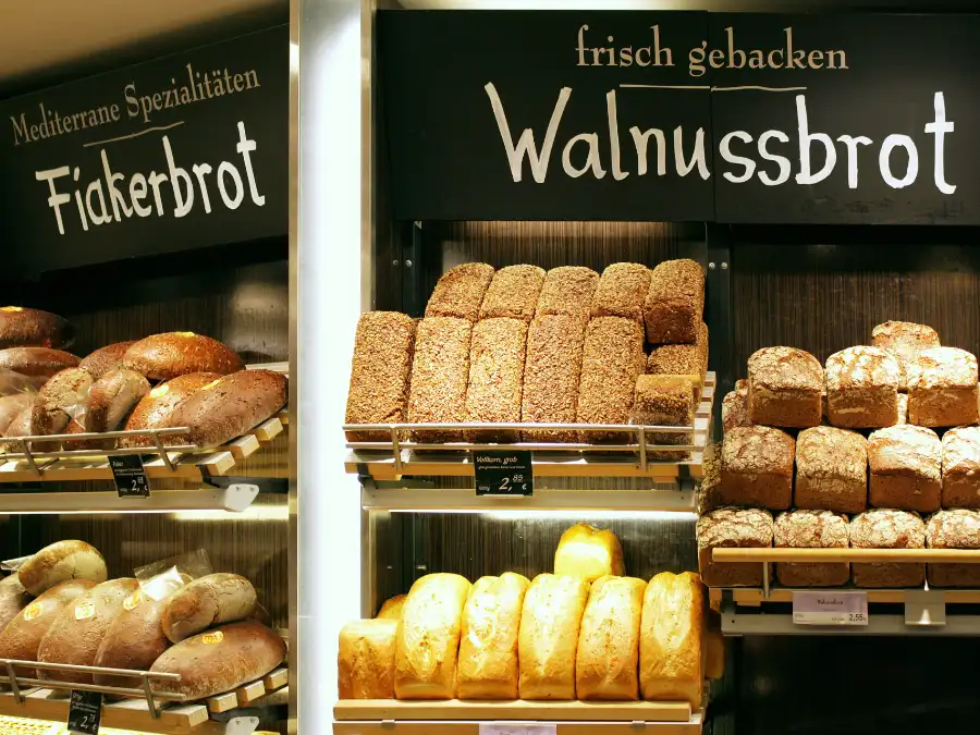 German bakery shelves stacked with loaves labeled Walnussbrot and Fiakerbrot, everyday food choices during Fastenzeit.