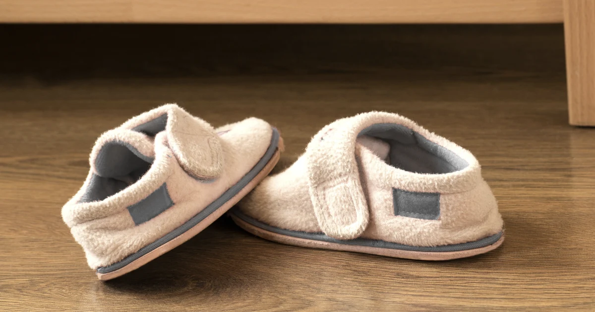 Small child's slippers on a wooden floor, the small habit that carries German cultural identity through a household.