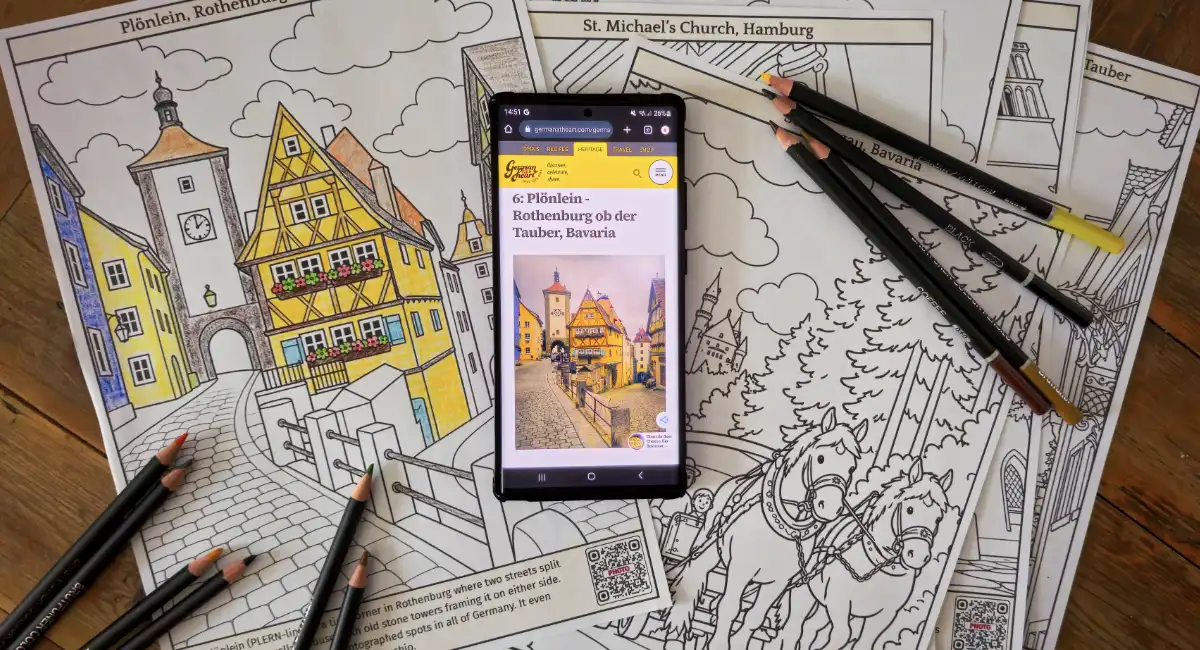 Printable Germany coloring pages for kids with German landmarks, colored pencils, and a Plönlein reference photo on a phone.