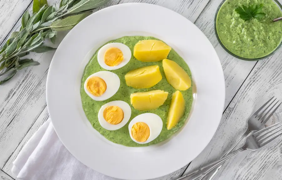 Frankfurter Grüne Soße green herb sauce served with halved hard-boiled eggs and boiled potatoes, traditional German Gründonnerstag dish