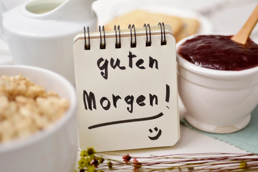 A handwritten 'guten Morgen' note on a breakfast table, the one-phrase habit that beats a Christmas market trinket.
