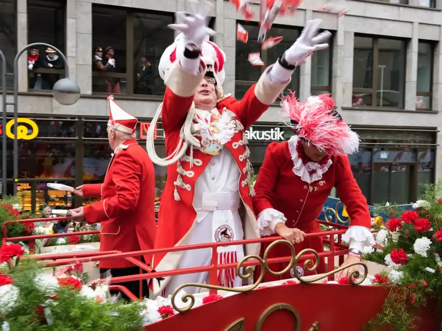 Cologne Karneval Rosenmontag float with costumed riders throwing Kamelle (sweets) into the crowd