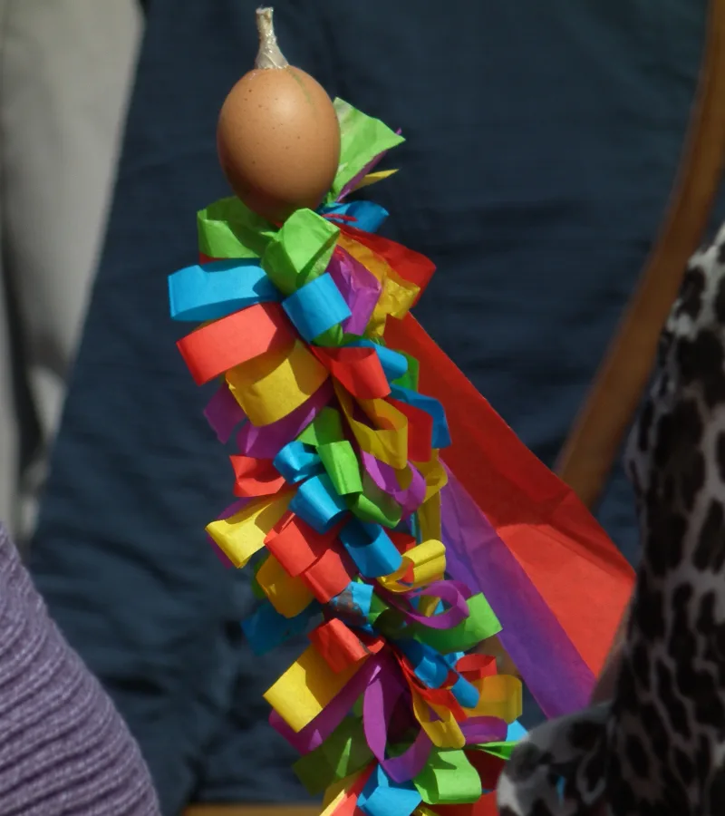 Sommertagsstecken decorated with colorful paper ribbons and an egg, carried during the Sommertagszug.