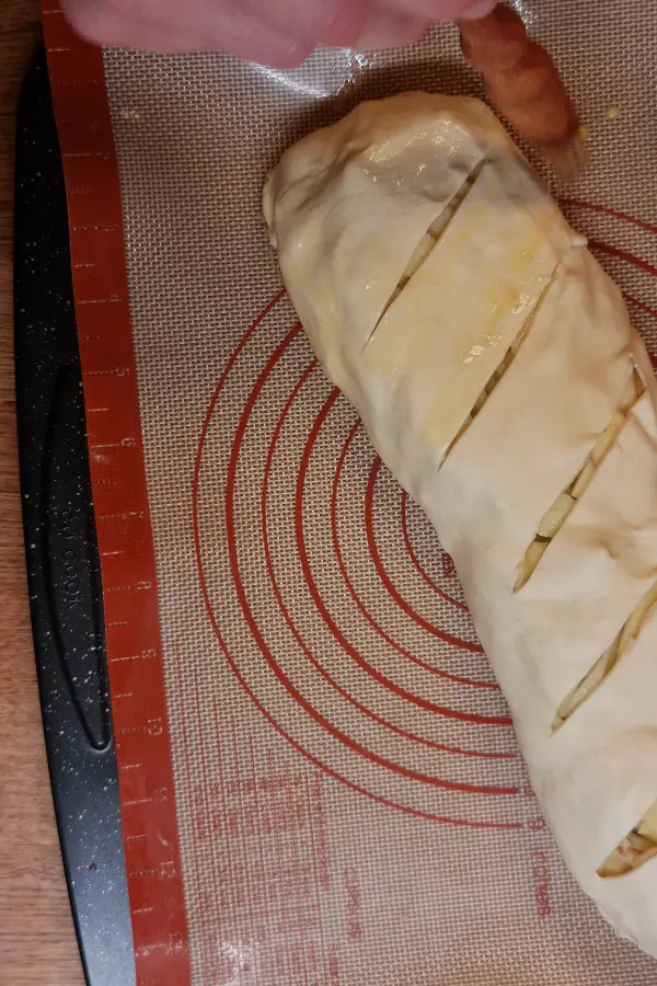 Egg wash being applied to a strudel.