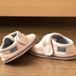Small child's slippers on a wooden floor, the small habit that carries German cultural identity through a household.