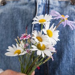 Child holding daisies behind their back for Muttertag